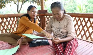 etani perempuan Desa Soso memegang sertipikat tanah program Reforma Agraria